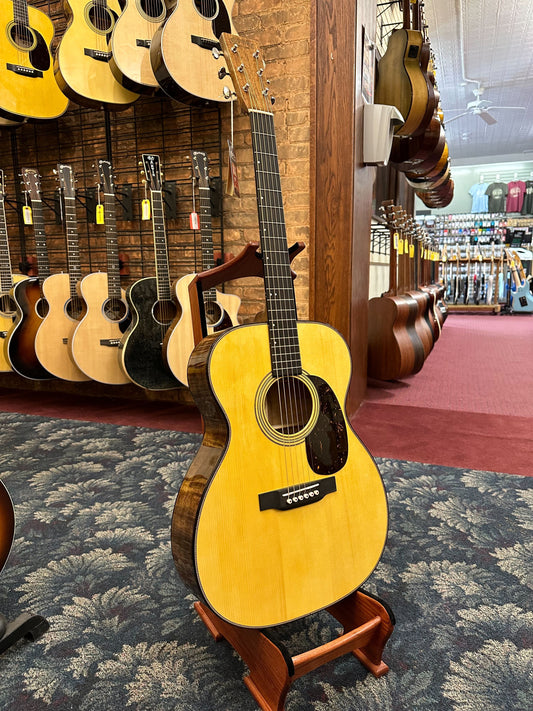 Showroom photo of Martin Custom 28-Style 000 Guitar & Case - Flame Koa & Adirondack Spruce