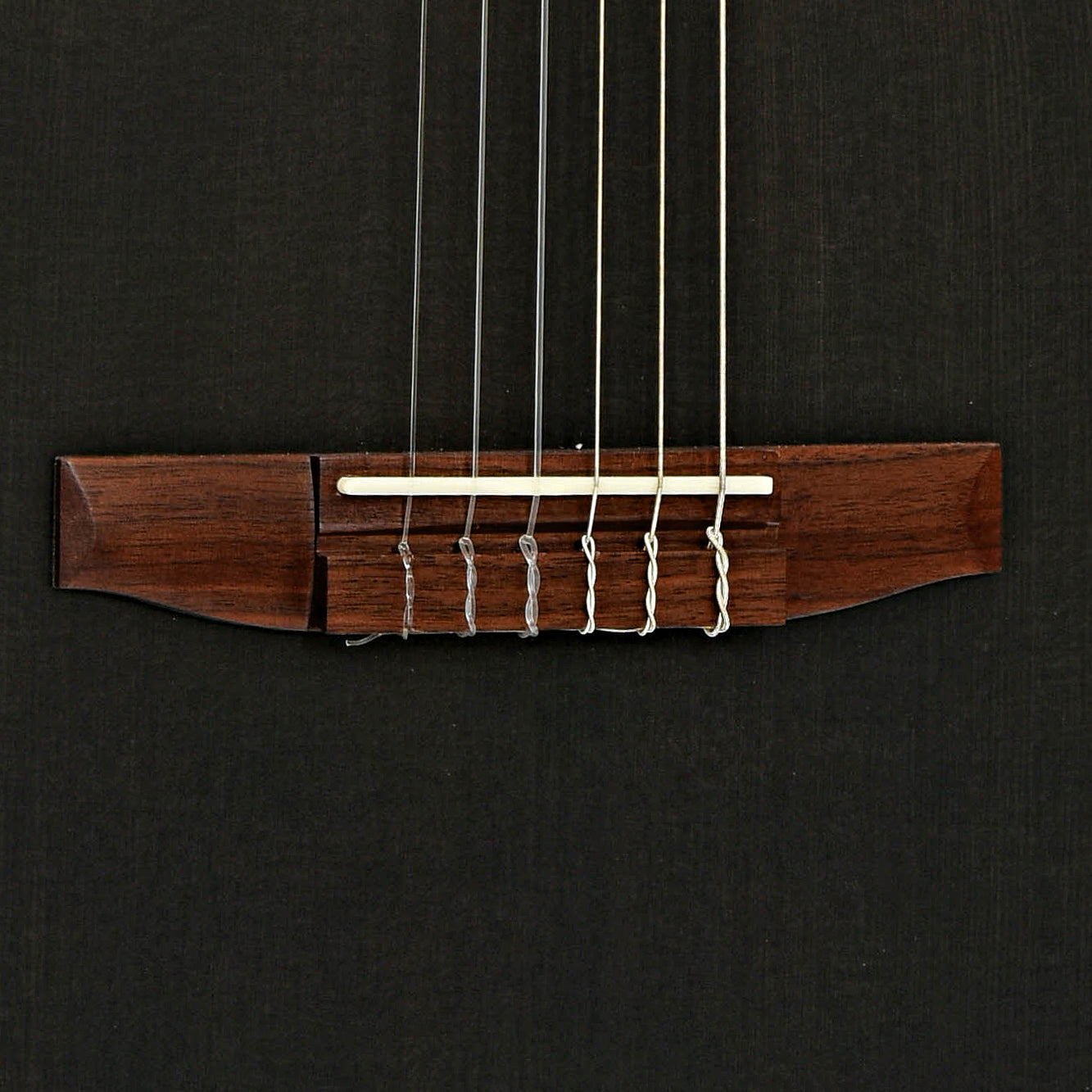 Bridge of Ibanez TOD10NL Tim Henson Signature Acoustic-Electric Nylon String Guitar - Left Handed, Transparent Black Flat