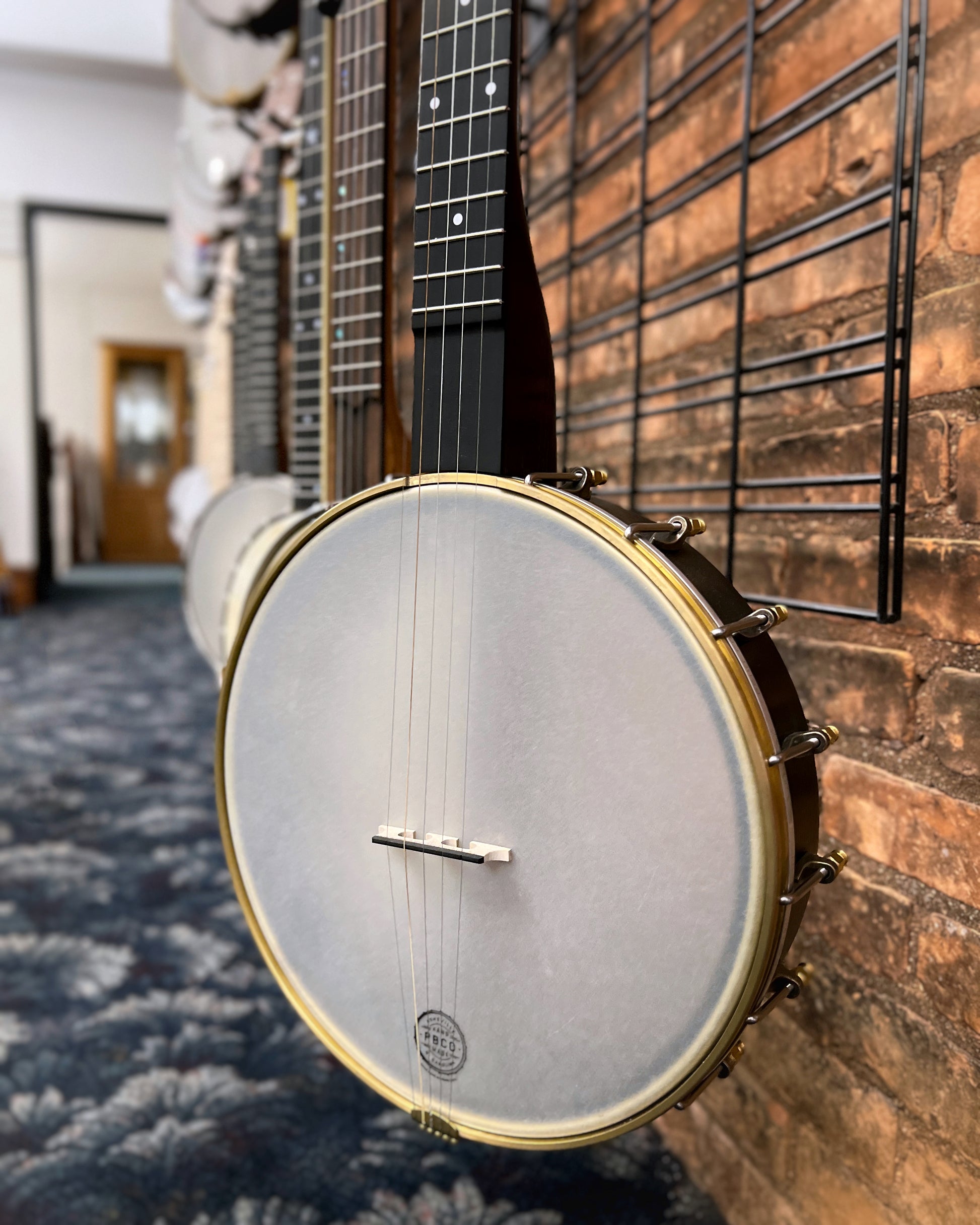 Showroom photo of front and side of Pisgah Banjo Co. 12" Woodchuck Openback Banjo